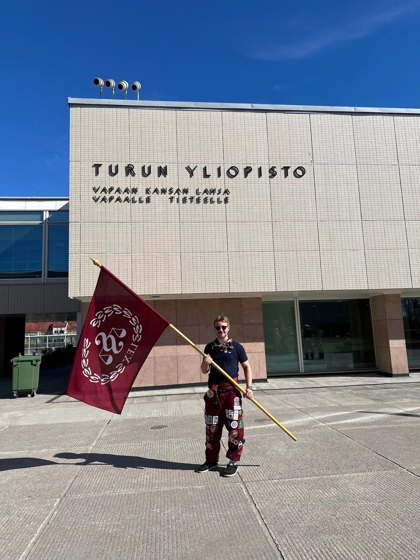 Jimi Turun yliopiston edustalla lippu kädessään